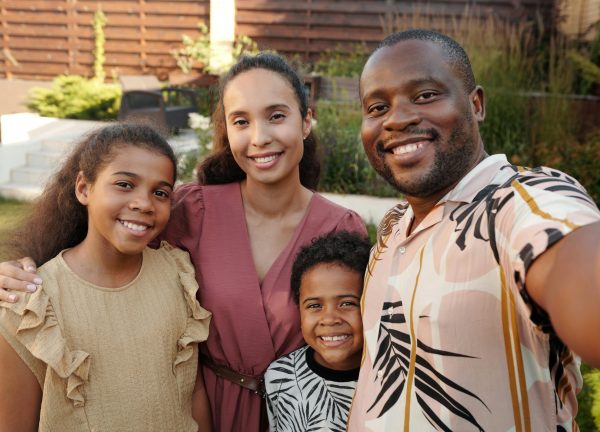 Smiling multicultural family enjoying time together outdoors in their garden.